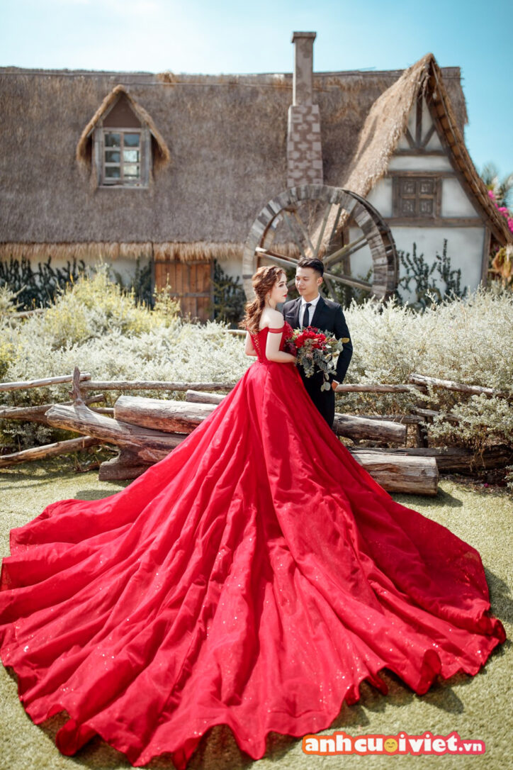 Cô dâu trong bộ váy đỏ bên cạnh chú rể 
